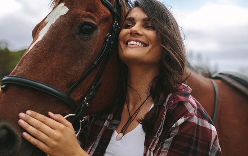 微笑的女子拥抱马